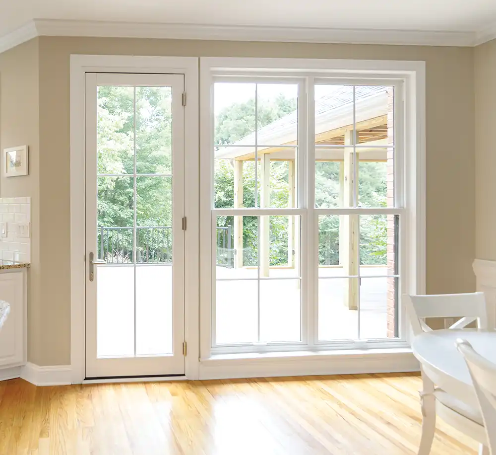 Cream colored home interior featuring a white Marvin Replacement Inswing French door.