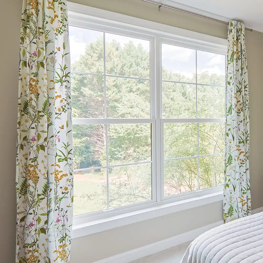Interior view of two side-by-side white bedroom double hung windows.