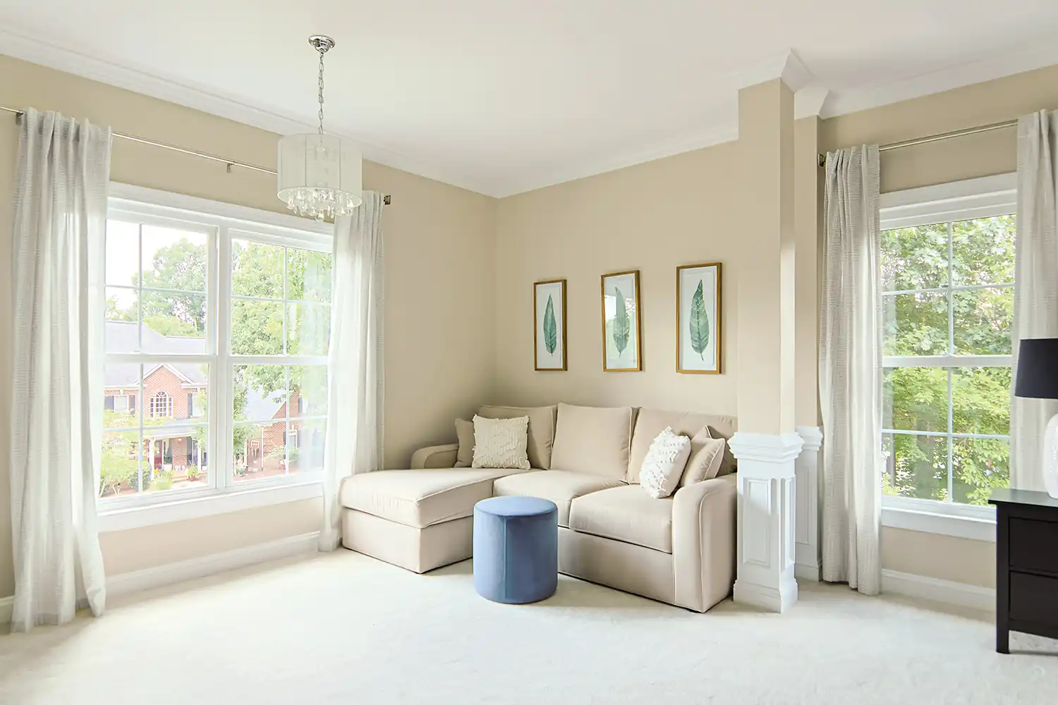 Bedroom interior with white double hung windows and view of a city street.