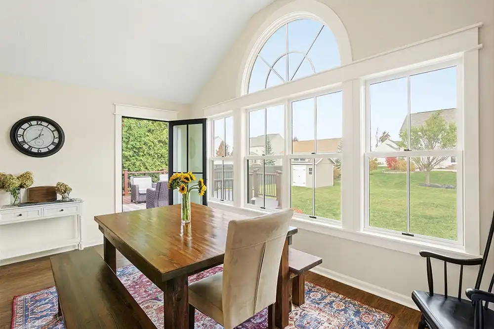 White dining room with double hung and arch window.