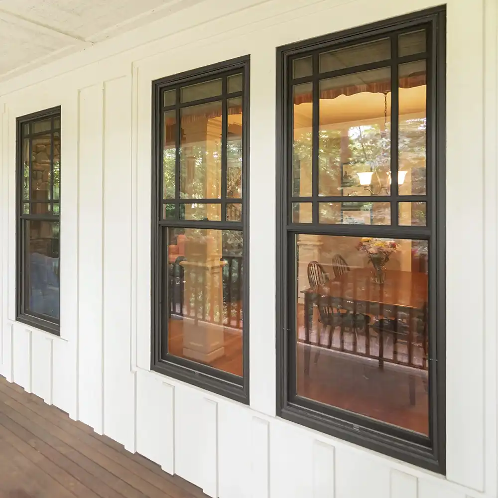 Exterior view of bronze Marvin Replacement double hung windows with prairie window grilles.
